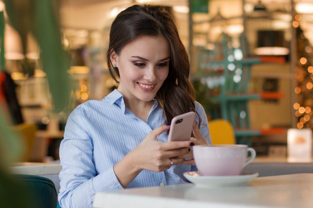 Clienta consultando la carta en su móvil en una cafetería